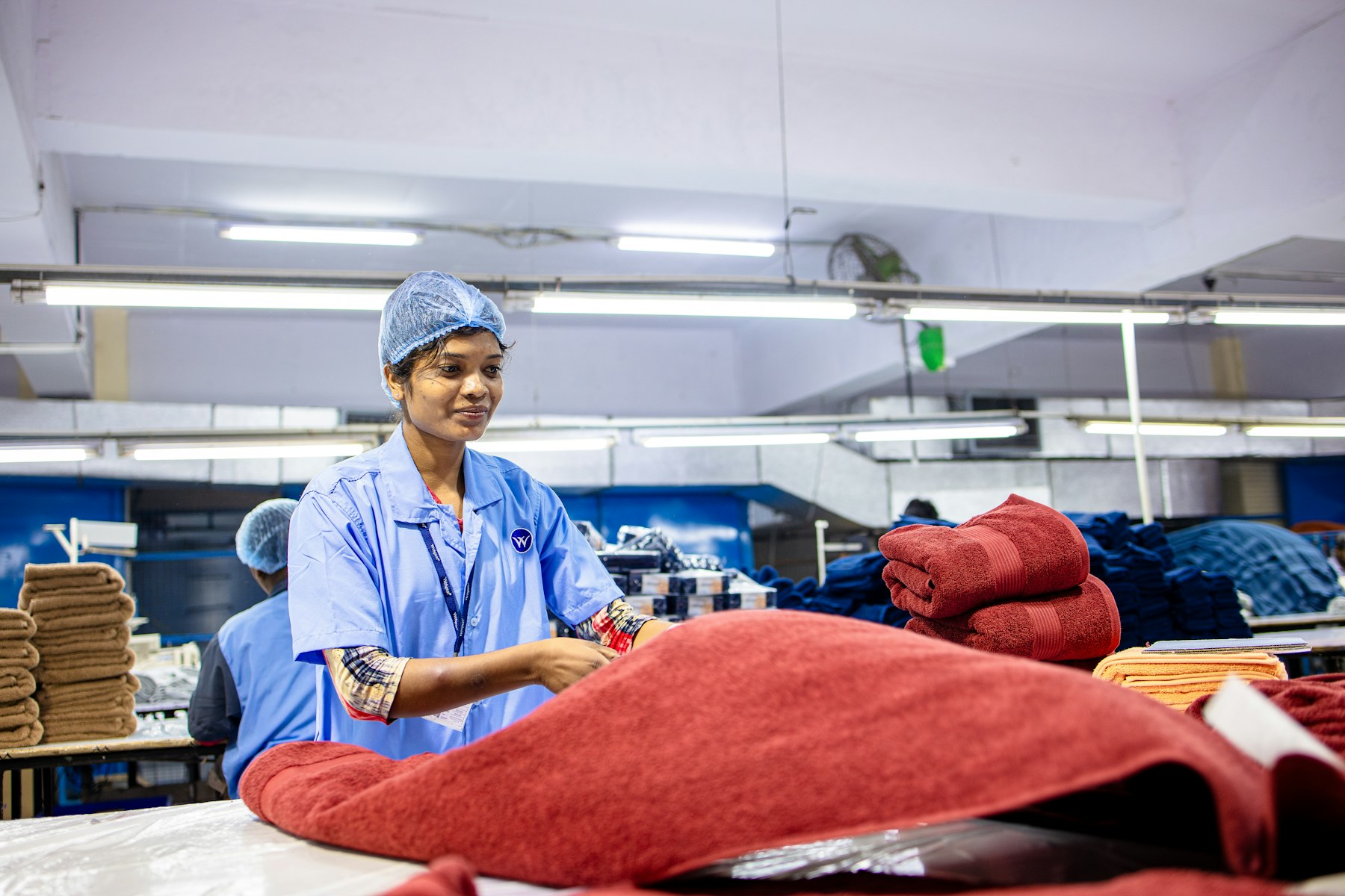 Textile worker handling towels in a factory